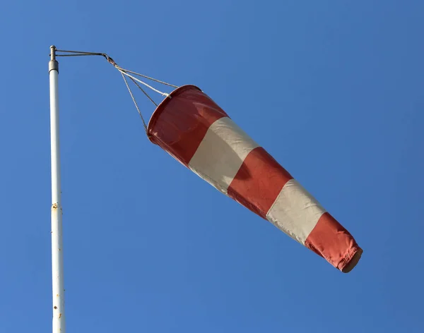 Moinho de vento vermelho e branco para sinalizar a direção do vento em um airpor — Fotografia de Stock