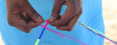 Afrikalı kadın bir saç modeli renkli kaplama ile hai yapar.