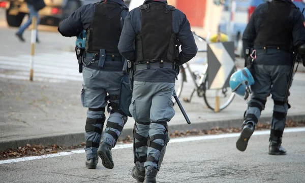 Trois policiers avec gilets pare-balles émeute en uniforme tapotement — Photo
