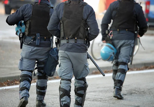 Trois policiers avec veste anti-balles en uniforme anti-émeute — Photo