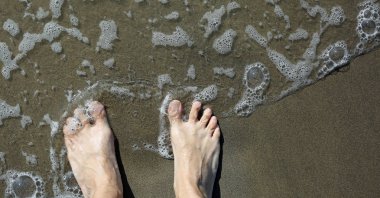 iki ayak barefoots bir yetişkinin deniz kıyısı ve dalga s