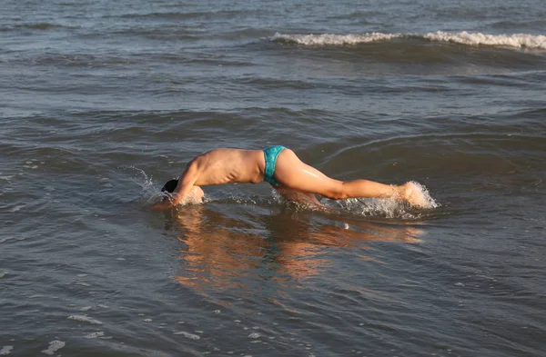 Enfant plonger au milieu des vagues de la mer — Photo