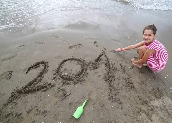 Mała dziewczynka, w pobliżu morza pisze tekst w roku 2017 — Zdjęcie stockowe