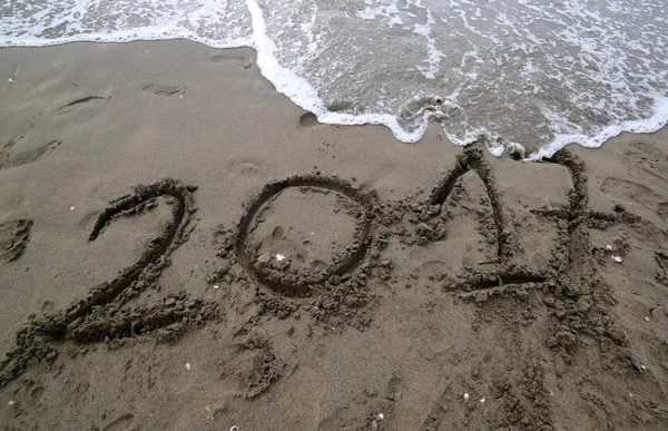 Texto en el año 2017 en la arena del mar esperando a ser cance — Foto de Stock