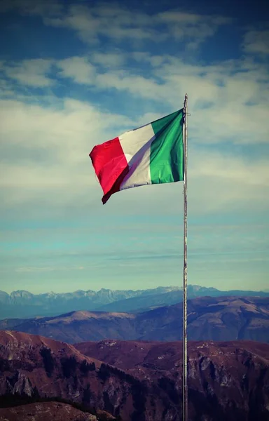 Italian flag waving above the top of the mountain with vintage e — Stock Photo, Image