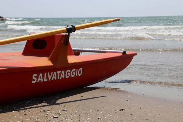 Barco de rescate en la orilla del mar con el gran SALVATAGGIO significa sa —  Fotos de Stock