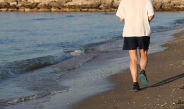 Sahilde deniz kenarında şafakta koşu kişi