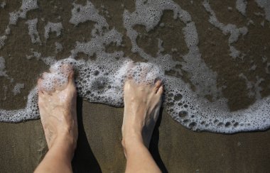 ayakları bir yetişkinin deniz kıyı ve belgili tanımlık sallamak