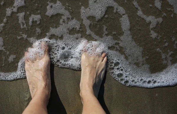 ayakları bir yetişkinin deniz kıyı ve belgili tanımlık sallamak