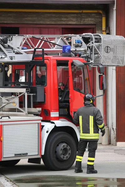 Пожежний і пожежна машина під час пожежних навчань — стокове фото