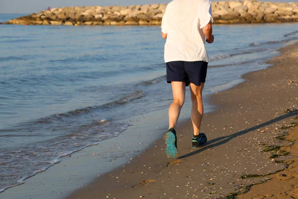 Ouderdomsdeken joggen op het strand door zee — Stockfoto