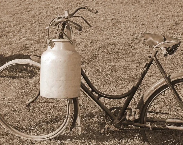 Fiets melkboer met de oude blikjes en sepia effect bin — Stockfoto