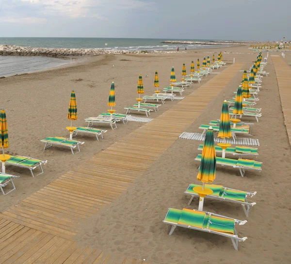 Strand napernyőkkel és nyugágyakkal néz életmentő — Stock Fotó