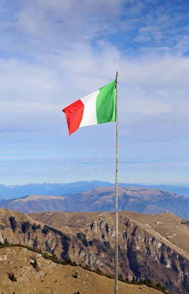 Bandiera italiana che sventola sopra la cima della montagna e della pianura — Foto Stock