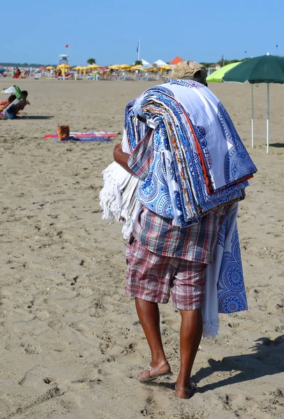 Жорстокий вуличний продавець з рушниками та тканинами на пляжі — стокове фото
