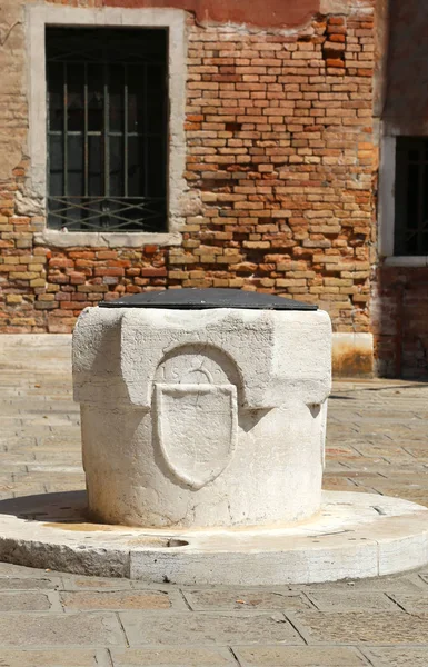 Antico pozzo in pietra in una piazza di una città europea — Foto Stock