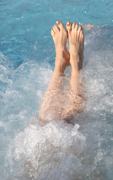 Fødder af ung kvinde under massage i poolen - Stock-foto