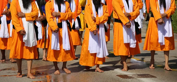 Grup de oameni desculți cu rochii portocalii în timpul religiei — Fotografie, imagine de stoc