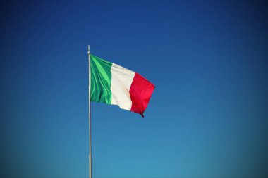 İtalyan bayrağı sallayarak vignette etkisi ile mavi gökyüzü ile