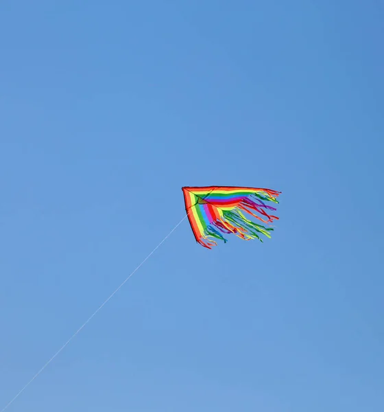 Воздушный змей летит высоко в голубом небе летом — стоковое фото