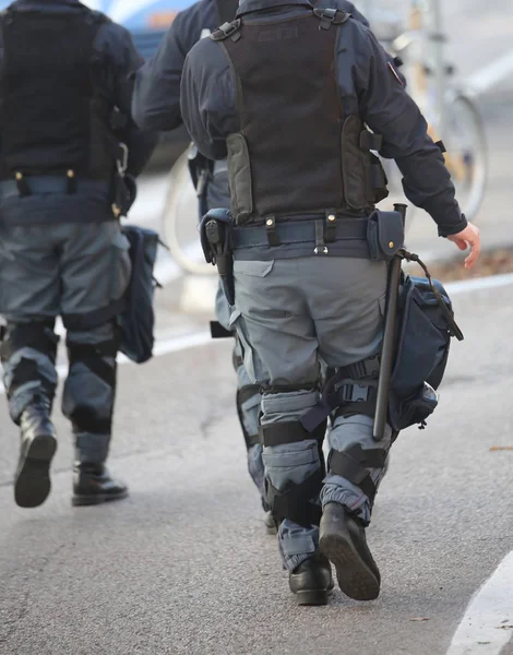 Politie patrouille in oproerpolitie met geweer en pistool tijdens de opstand — Stockfoto