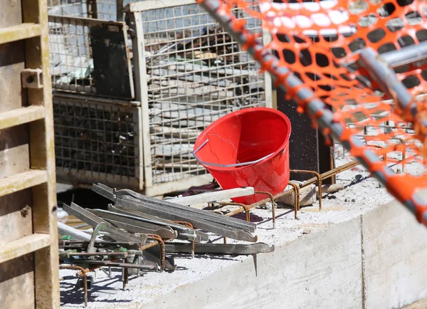 Şantiye duvar s sırasında kırmızı plastik kova — Stok fotoğraf