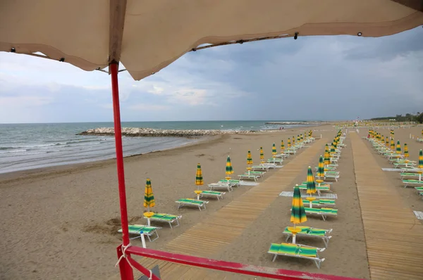 Série de guarda-chuvas e espreguiçadeiras do salva-vidas assistindo t — Fotografia de Stock