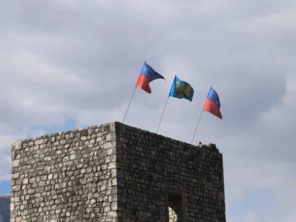 Tres banderas en la antigua torre en el norte de Italia —  Fotos de Stock