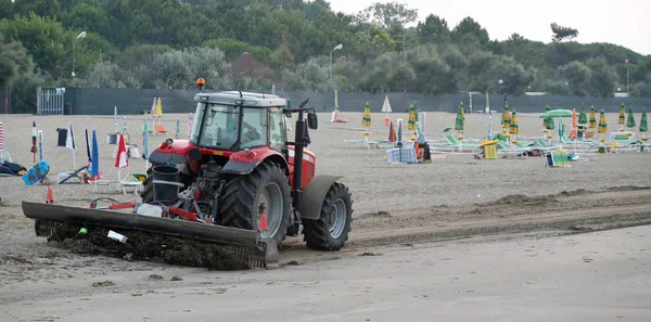 Trattore che pulisce la spiaggia all'alba dai rifiuti del giorno — Foto Stock