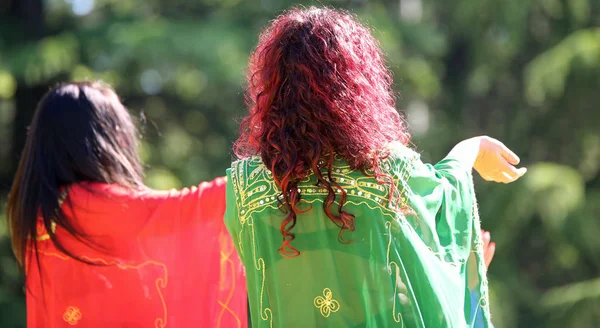 Twee langharige vrouwen in een sensuele dans met gekleurde kleding — Stockfoto