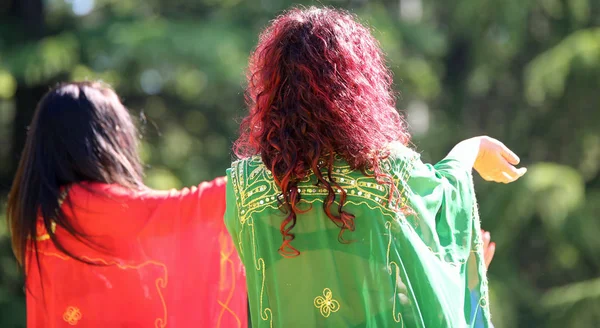 Two long-haired women in a sensual dance with colored clothes — Stock Photo, Image