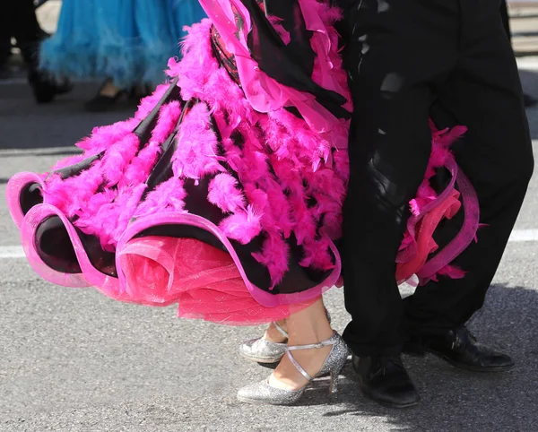 woman with fuchsia dress while dancing with a man on the road