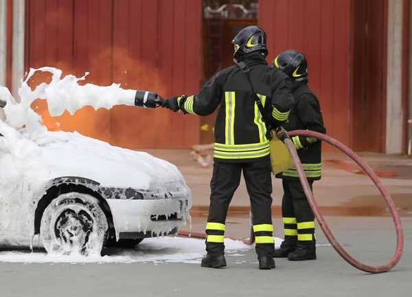 Πυροσβέστες με αφρίζει φωτιά από την πυρκαγιά του αυτοκινήτου — Φωτογραφία Αρχείου