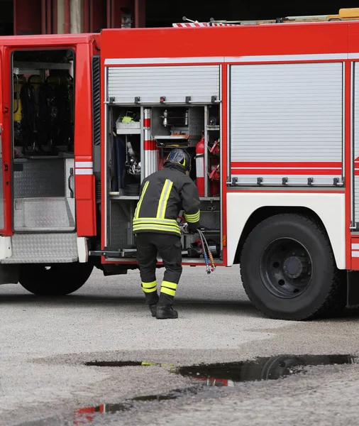 A tűzoltók és a tűzoltókocsi — Stock Fotó