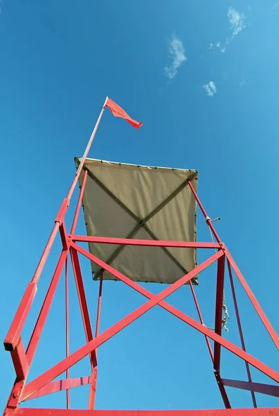 Bademeister-Turm am Strand mit der roten Flagge — Stockfoto