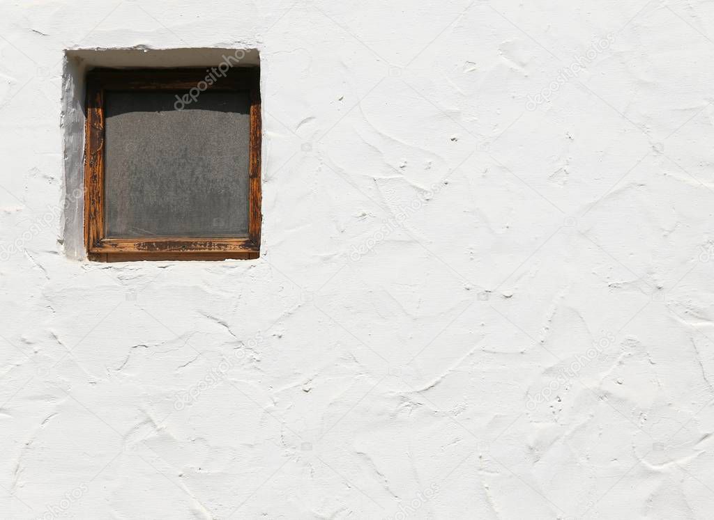 little square window and the white wall