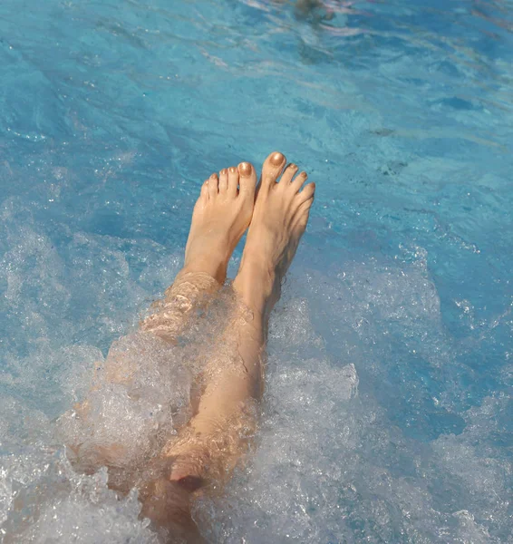 Feet of a young woman with nails with enamel during whirlpool — Stockfoto