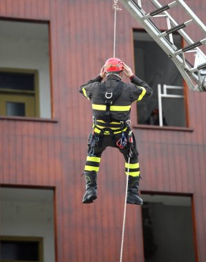 Kırmızı kask ile cesur kurtarıcı sırasında platformdan iner 