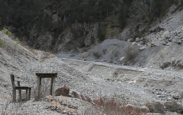 Rural scene with the dry riverbed so many stones and a table wit — Stock Photo, Image