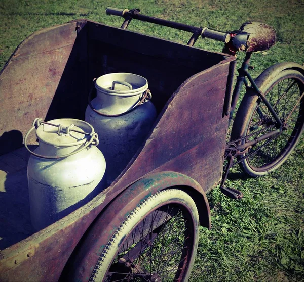 Two old milk cans transported by an old wagon — Stock Photo, Image