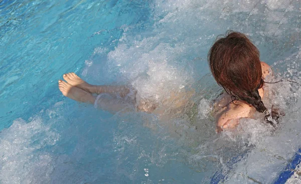 Kvinna under hydromassage sitter i poolen i ett lyxigt spa — Stockfoto
