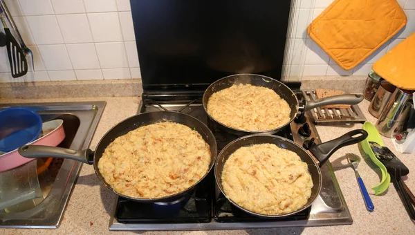 Três grandes panelas com a comida chamada frico um recip típico italiano — Fotografia de Stock