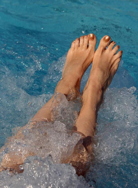Fötter av en kvinna med naglar med emalj under whirlpool i p — Stockfoto