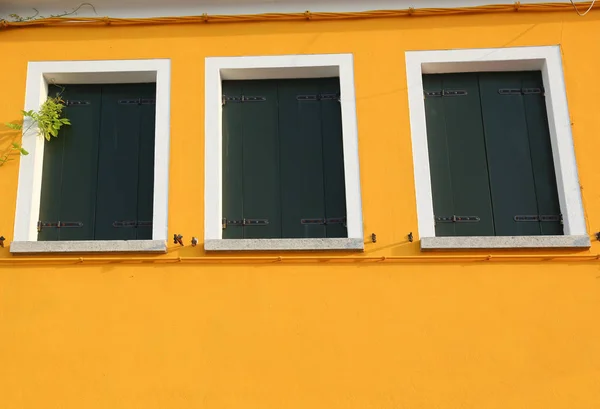 Haus mit gelber Wand und 3 geschlossenen Fenstern — Stockfoto