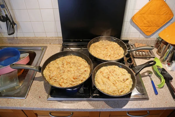 Tre padelle grandi con il cibo chiamato frico un piatto tipico italiano — Foto Stock