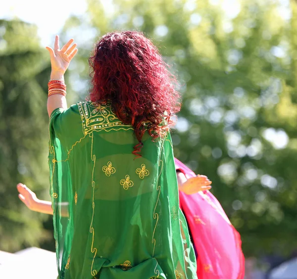 Vrouw met lange haren tijdens een sensuele dans met kostbare groene — Stockfoto
