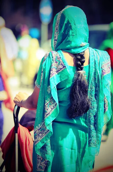 Mujer joven con vestido decorado y larga trenza de pelo negro comin — Foto de Stock