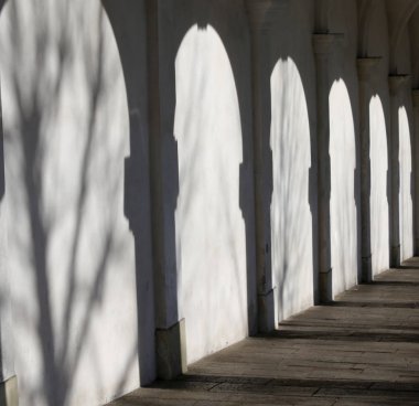 beyaz duvar ile bir arcade birçok gölgeler