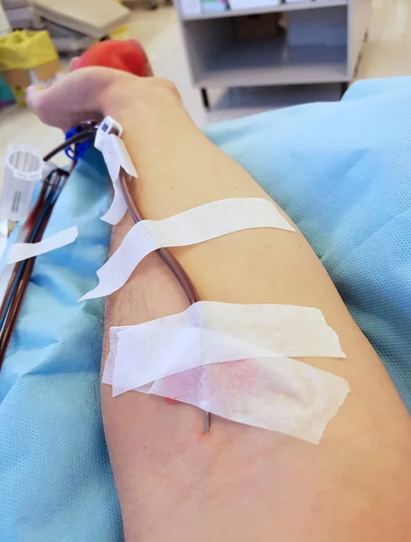 Donneur de sang volontaire avec aiguille chirurgicale dans la chair à la h — Photo