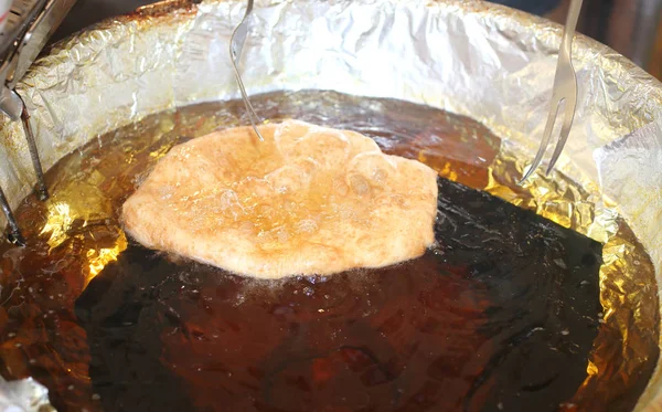 Блинчики в кастрюле с горячим маслом в кабинке на улице — стоковое фото